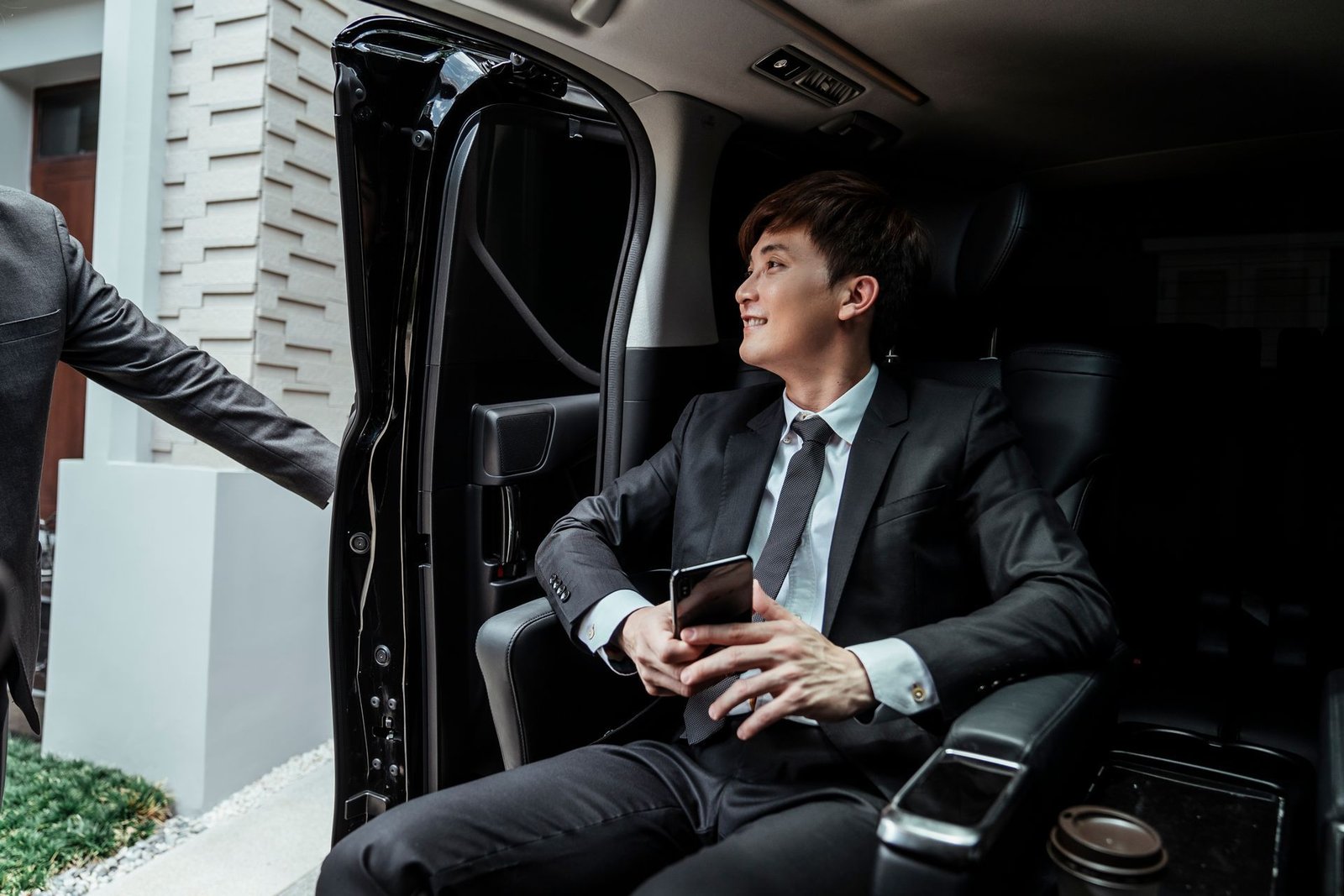 Man in suit seated in a luxury car