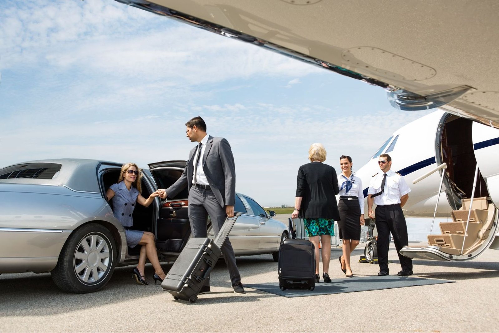People boarding a private jet with a limousine on the tarmac