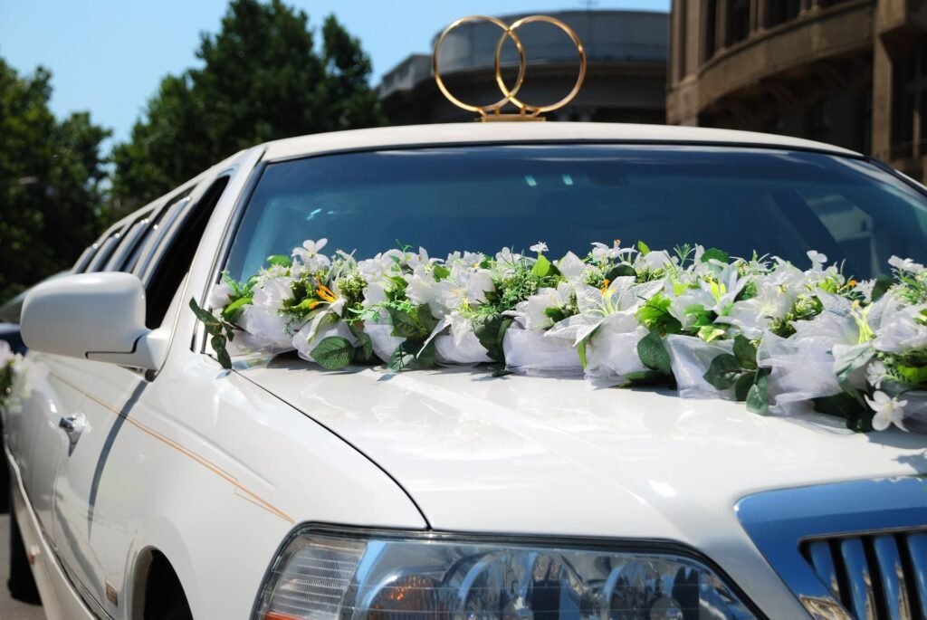 White wedding limousine decorated with white flowers and gold rings