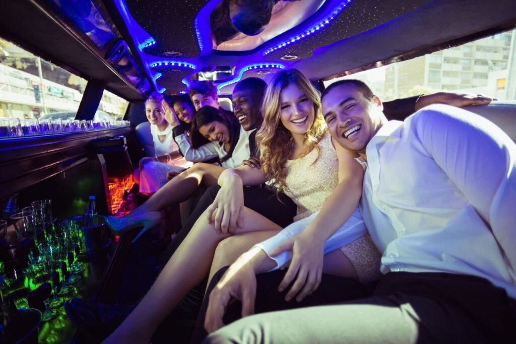 Group of friends smiling and celebrating inside a limousine with colorful lights